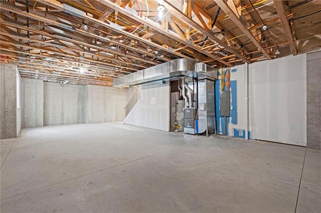 basement featuring electric panel and heating unit