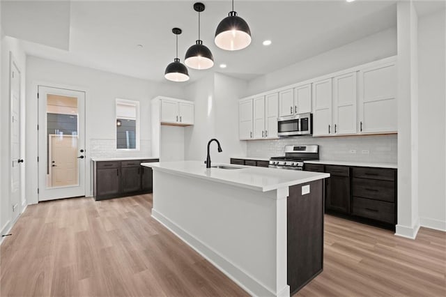 kitchen featuring white cabinetry, appliances with stainless steel finishes, sink, and light wood-type flooring