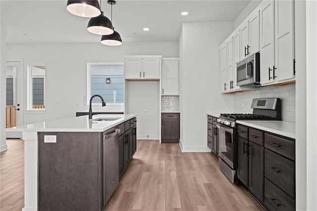 444 SW Brummel Rd, Lees Summit, MO 64081 - kitchen with stainless steel appliances, a sink, white cabinetry, light wood-type flooring, and light countertops