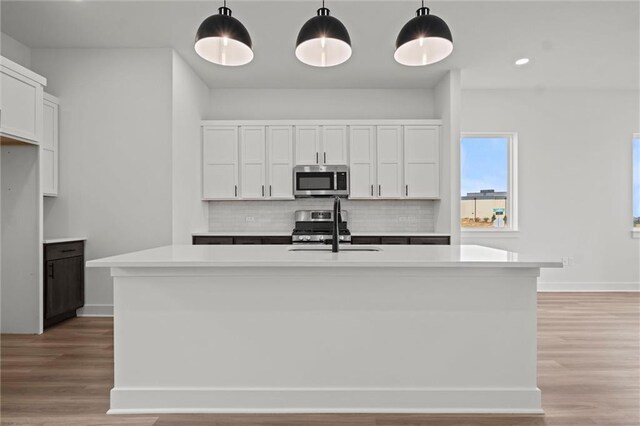 448 SW Brummel Rd, Lees Summit, MO 64081 - kitchen featuring stainless steel appliances, a sink, tasteful backsplash, light countertops, and white cabinetry