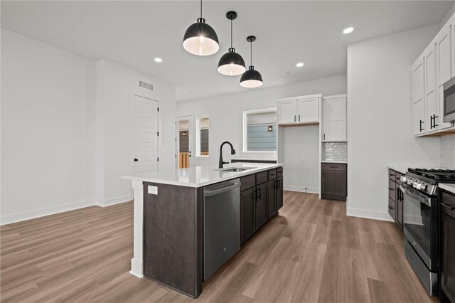 448 SW Brummel Rd, Lees Summit, MO 64081 - kitchen featuring stainless steel appliances, a sink, light wood finished floors, white cabinetry, and recessed lighting