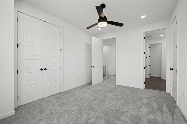 unfurnished bedroom featuring light colored carpet, ceiling fan, and a closet