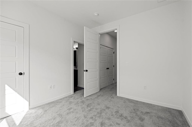 unfurnished bedroom featuring light colored carpet and a closet