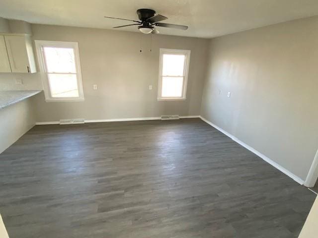 interior space featuring plenty of natural light, ceiling fan, and dark hardwood / wood-style floors