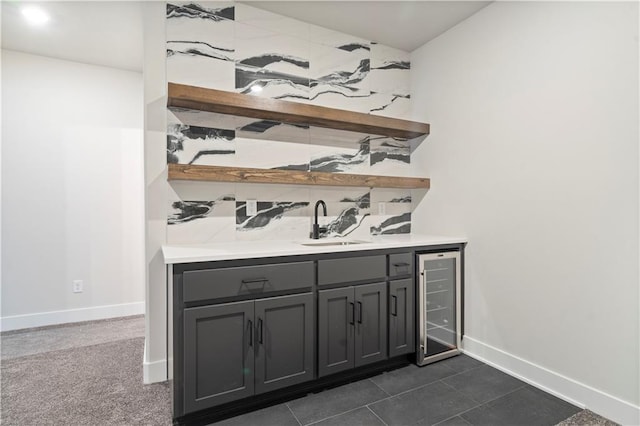 bar featuring gray cabinets, sink, dark carpet, and beverage cooler