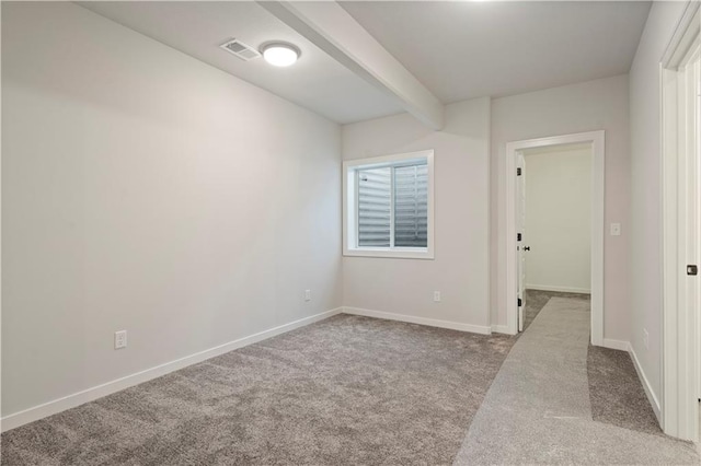 carpeted spare room featuring beam ceiling