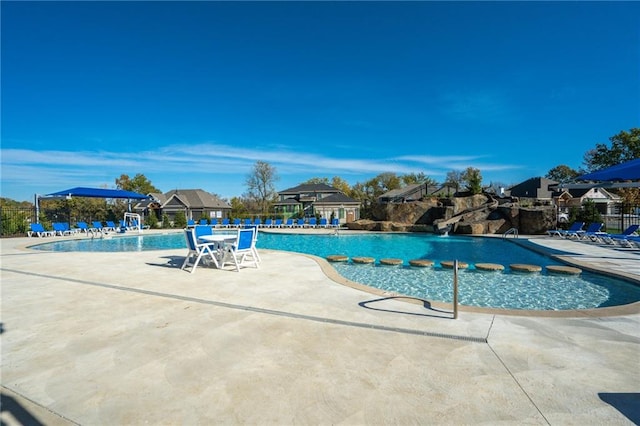 view of swimming pool featuring pool water feature and a patio area