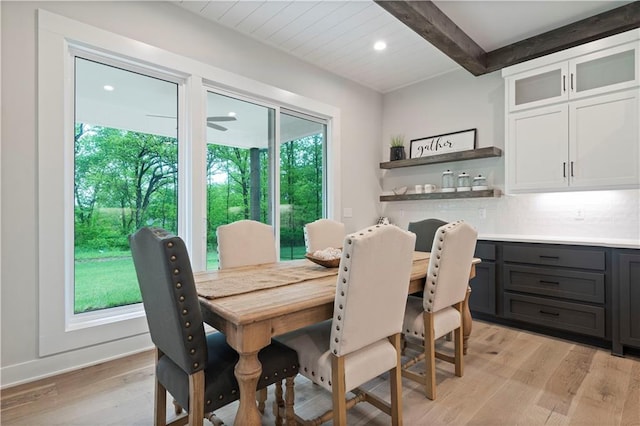 dining space featuring light hardwood / wood-style floors and beam ceiling