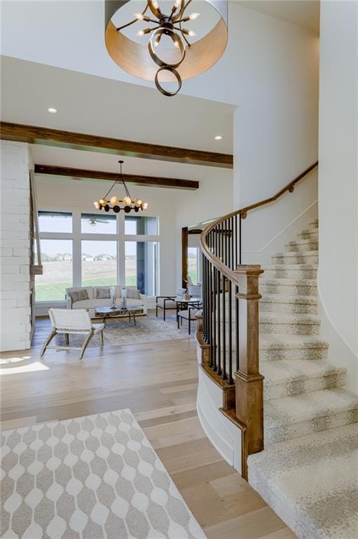 interior space featuring a tray ceiling, a notable chandelier, hardwood / wood-style flooring, and a high ceiling