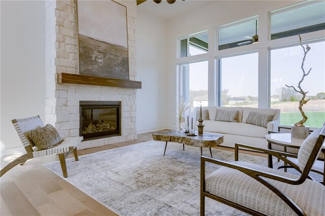 living room with a healthy amount of sunlight, hardwood / wood-style flooring, a fireplace, and ceiling fan