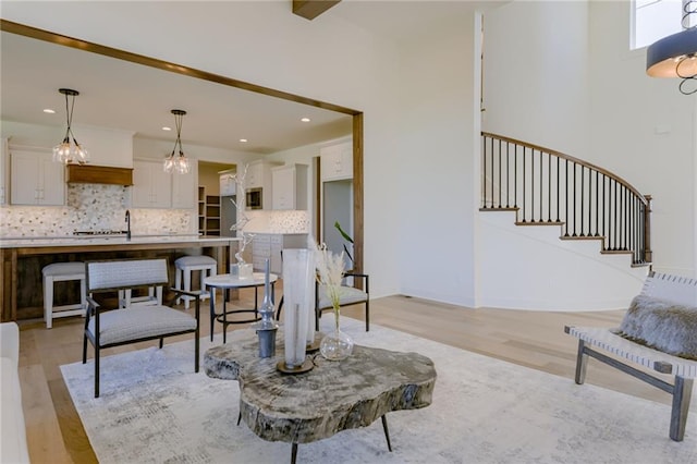 living room with an inviting chandelier and light hardwood / wood-style flooring