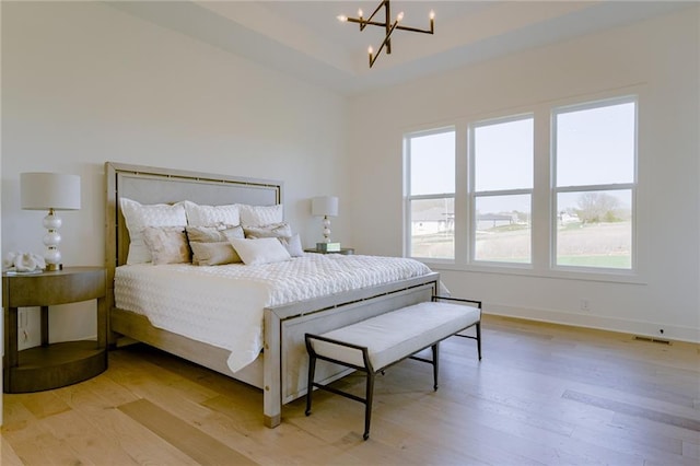 bedroom with a notable chandelier and wood-type flooring