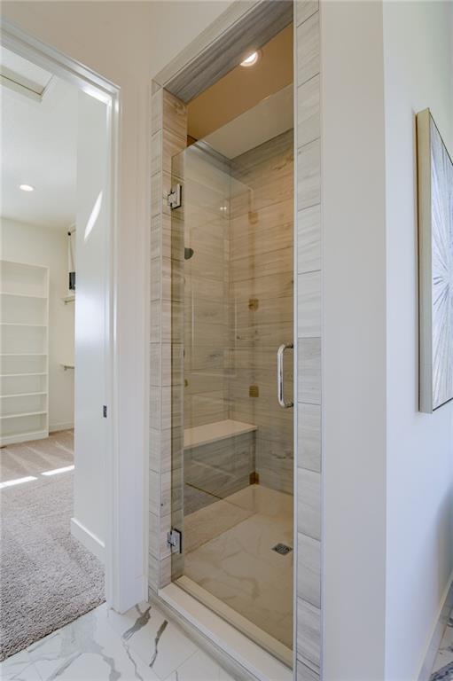 bathroom featuring tile flooring and an enclosed shower