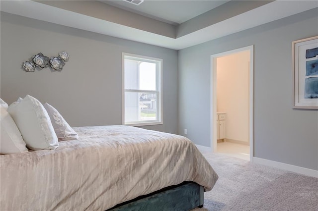 carpeted bedroom featuring ensuite bath