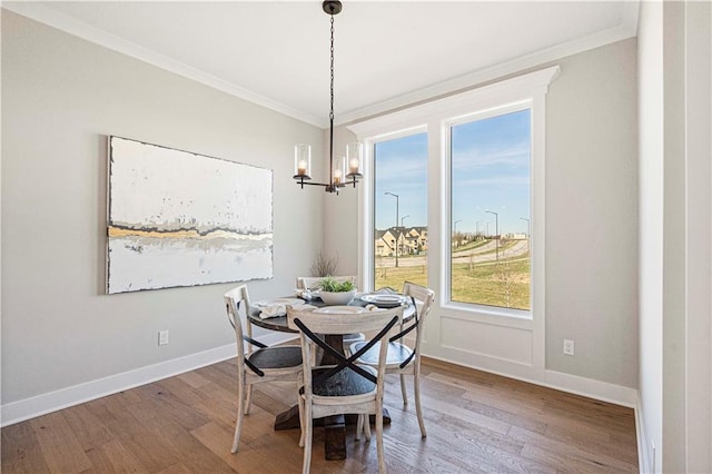 dining room featuring crown molding, a notable chandelier, and hardwood / wood-style flooring