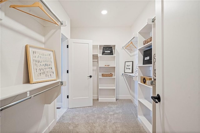 walk in closet with light colored carpet