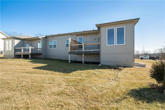 rear view of property featuring a yard and a deck