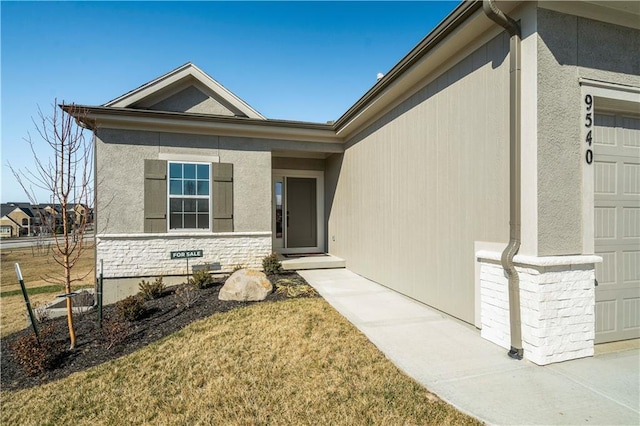 entrance to property with a yard and a garage