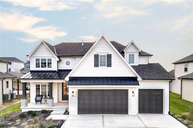 view of front of home featuring central AC unit, a garage, and covered porch