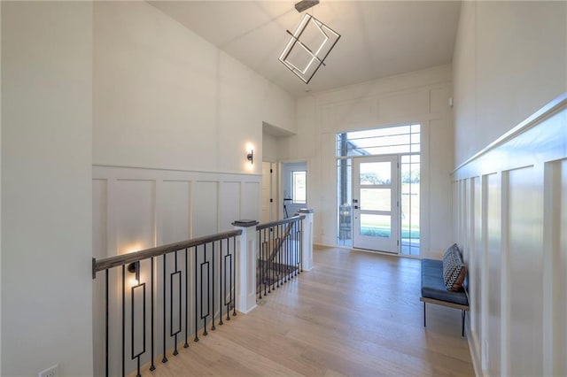 hallway featuring light hardwood / wood-style flooring and a high ceiling