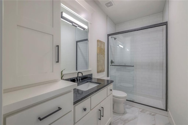 bathroom with vanity, a shower with door, and toilet