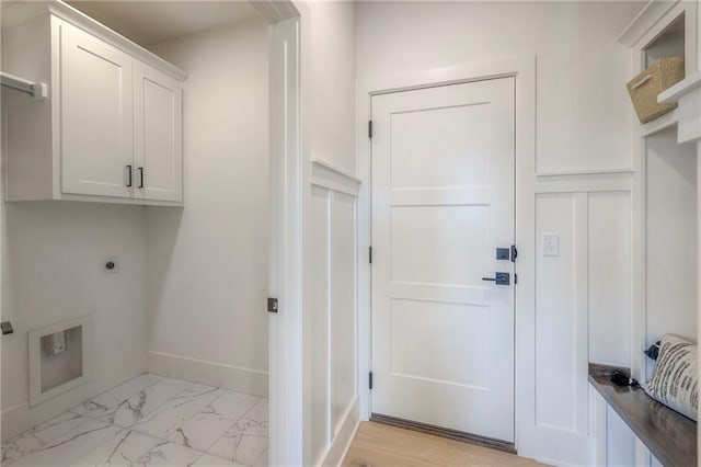 clothes washing area featuring cabinets and electric dryer hookup