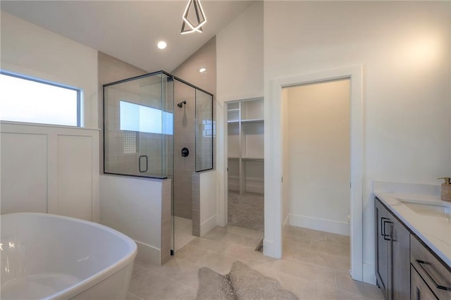 bathroom with shower with separate bathtub, vaulted ceiling, tile patterned flooring, and vanity