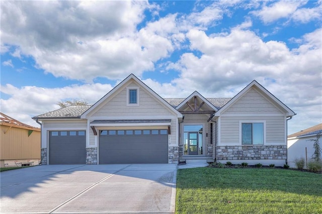 craftsman-style home featuring a front yard and a garage