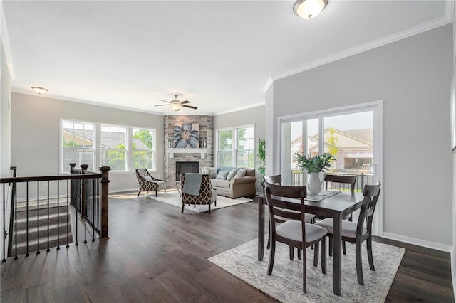 dining room with ornamental molding, dark hardwood / wood-style flooring, a fireplace, and ceiling fan