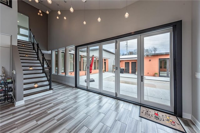 doorway to outside with high vaulted ceiling and french doors