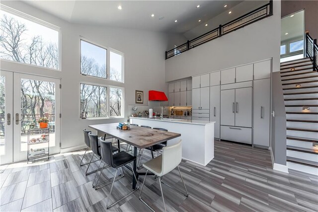 dining area with high vaulted ceiling, french doors, and sink