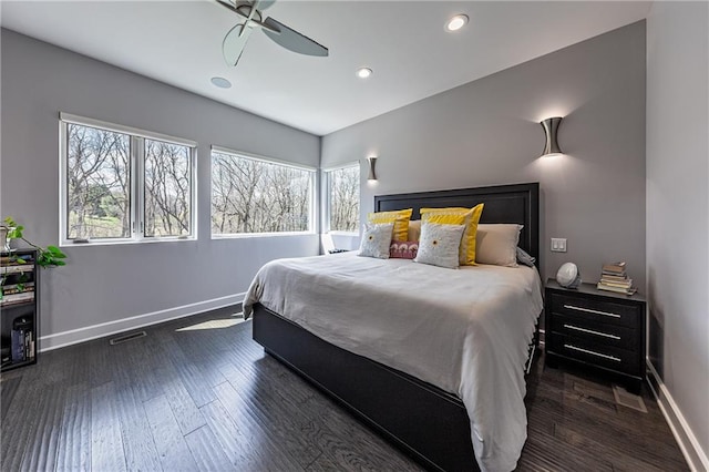 bedroom with ceiling fan, multiple windows, and dark hardwood / wood-style flooring