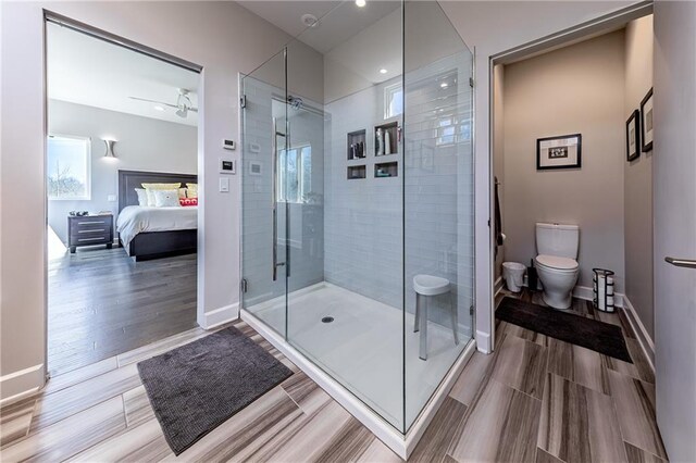 bathroom featuring an enclosed shower, wood-type flooring, ceiling fan, and toilet