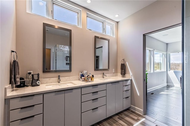 bathroom featuring oversized vanity, double sink, hardwood / wood-style flooring, and a bathtub