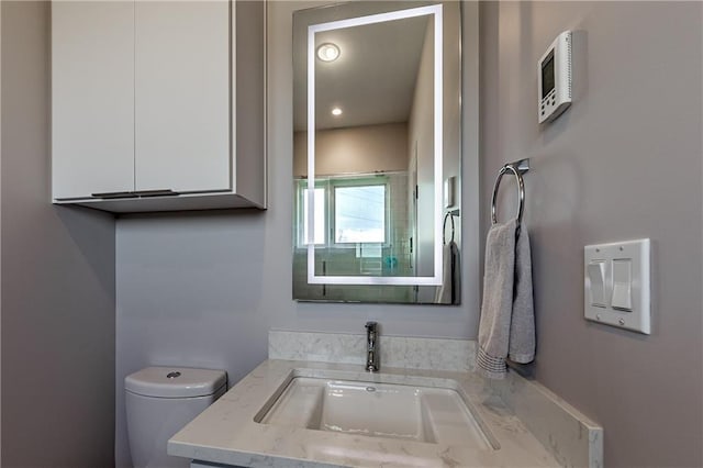 bathroom featuring oversized vanity and toilet