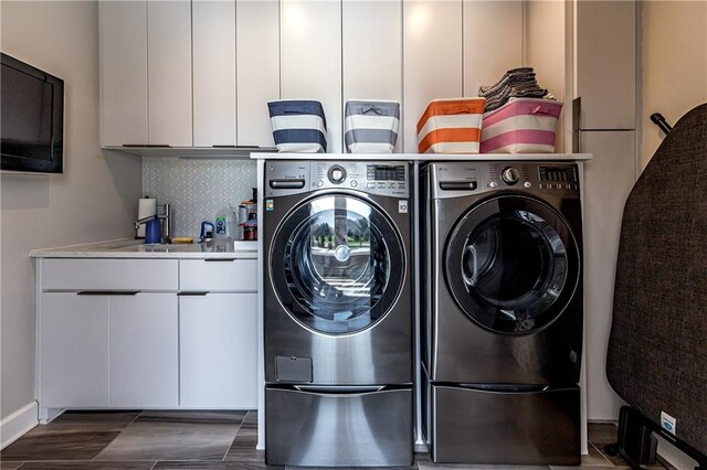 washroom featuring sink, cabinets, and washing machine and clothes dryer