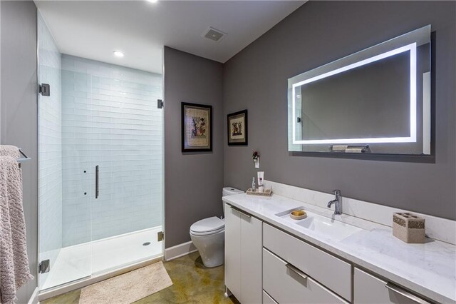 bathroom featuring tile floors, a shower with door, vanity, and toilet