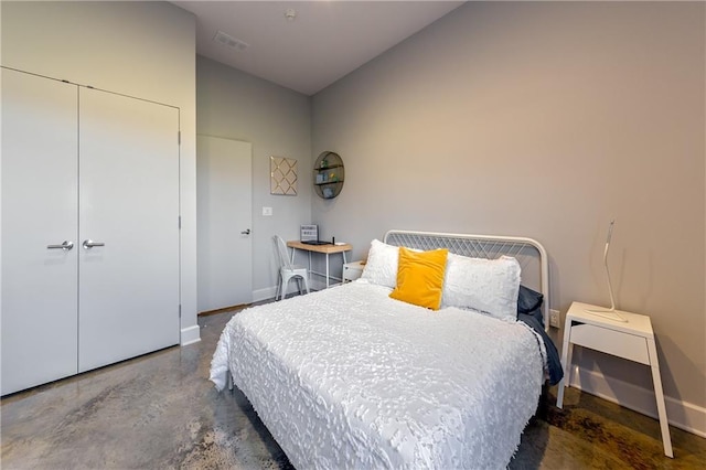 bedroom with a closet and concrete flooring