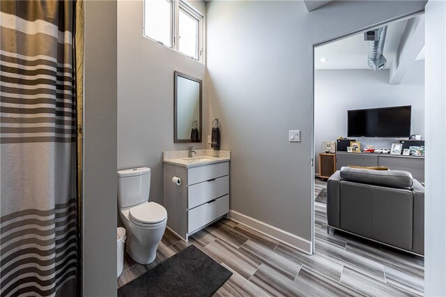 bathroom with a towering ceiling, toilet, and vanity