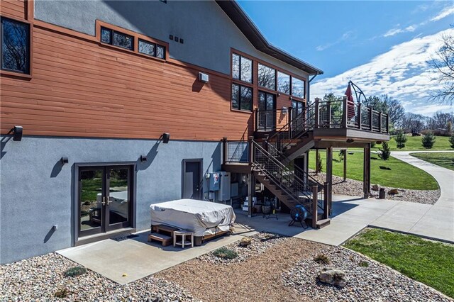 back of property with a patio, a wooden deck, and a yard