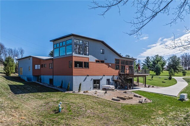 back of property featuring a patio area, a wooden deck, and a yard