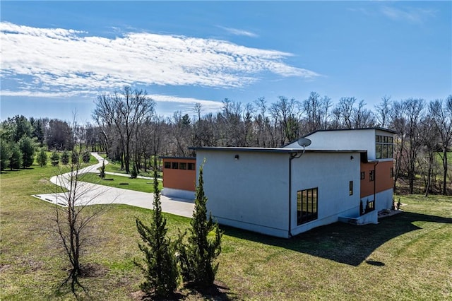 view of side of property featuring a garage and a yard