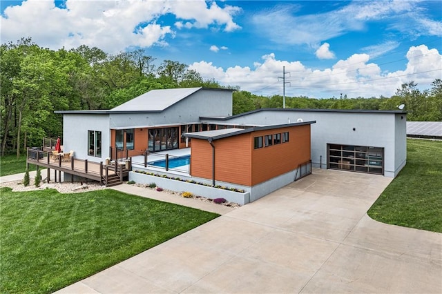 contemporary house with a front yard and a pool side deck