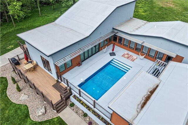 view of swimming pool with a deck, a patio area, and a yard