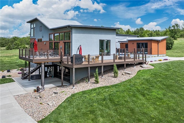 rear view of house featuring a deck and a yard