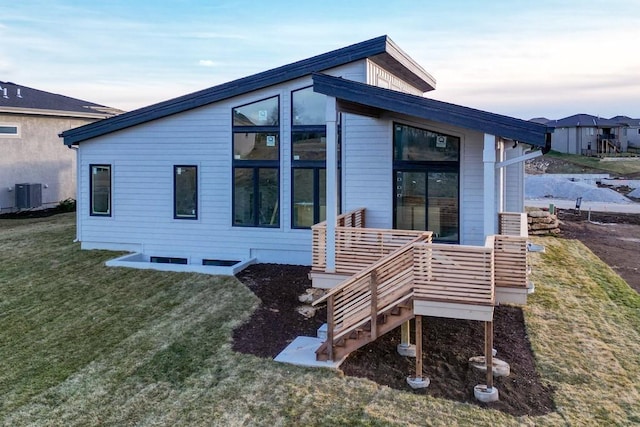 view of front of property with central AC unit and a front lawn