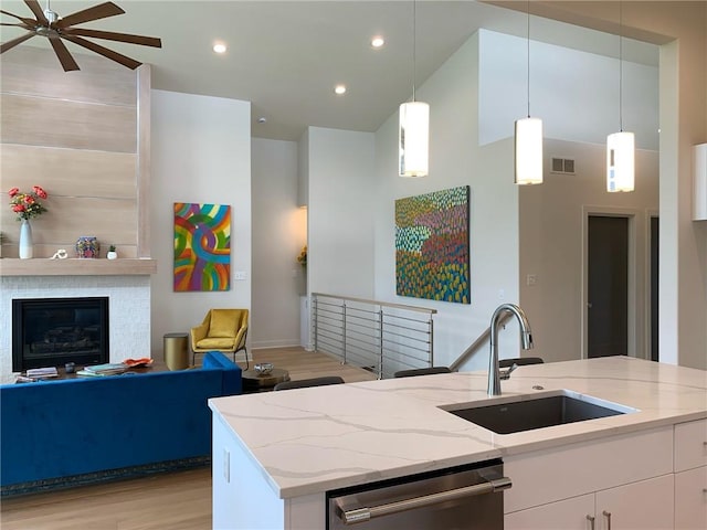 kitchen with dishwasher, ceiling fan, white cabinetry, light wood-type flooring, and sink