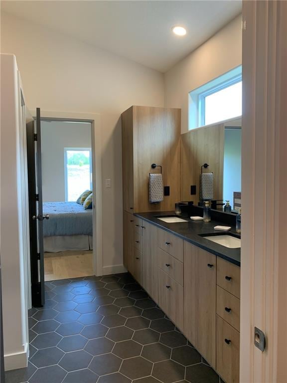 bathroom featuring tile flooring, plenty of natural light, double sink, and vanity with extensive cabinet space