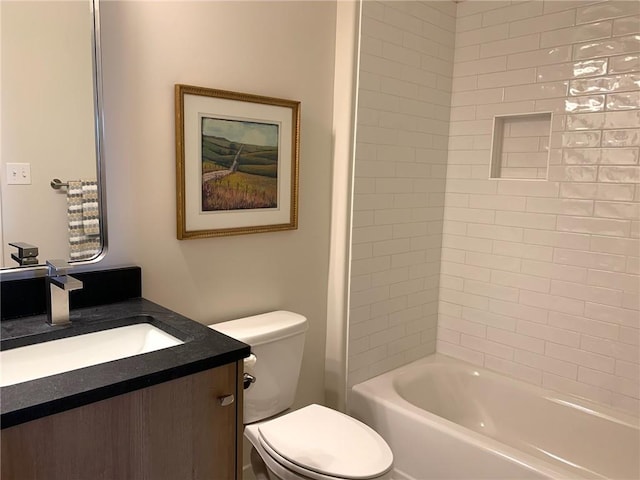 full bathroom featuring tiled shower / bath combo, toilet, and vanity