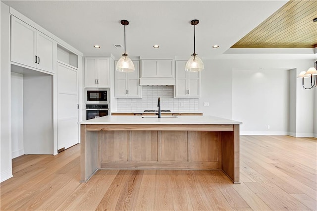 kitchen featuring light countertops, premium range hood, oven, baseboards, and built in microwave
